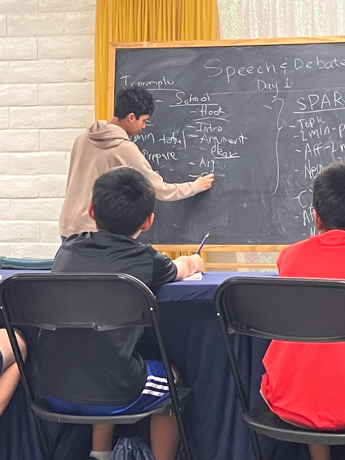 Debate students writing notes in 2024 camp
